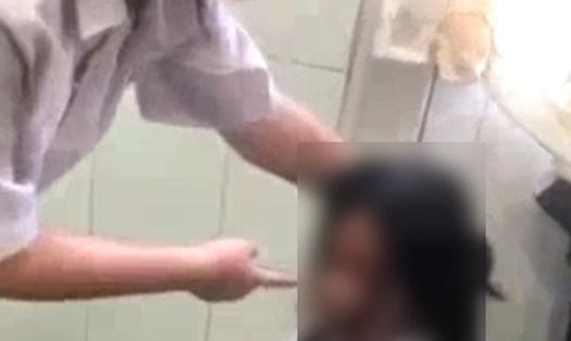 Nữ học sinh lớp 8 quỳ xuống sàn nhà vệ sinh, hứng chịu tát tai, đấm, đá của các nữ sinh khác. Ảnh cắt từ video.