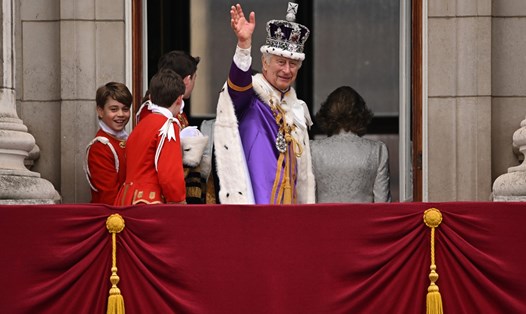 Vua Charles III vẫy tay từ ban công Điện Buckingham sau khi xem Lực lượng Không quân Hoàng gia trình diễn máy bay chào mừng lễ đăng quang. Ảnh: AFP