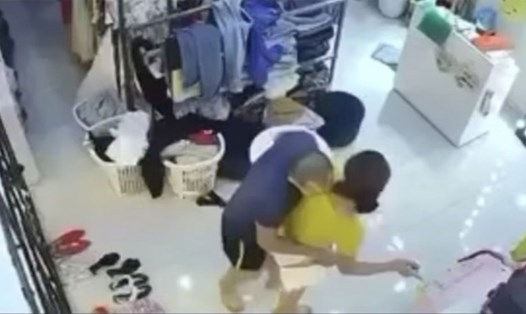 Nữ chủ shop quần áo bị người đàn ông khống chế, đòi hiếp dâm. Ảnh cắt từ camera