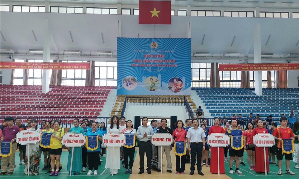 Phó Chủ tịch Liên đoàn Lao động thành phố Nguyễn Chính Hữu (hàng trên, thứ 5 từ phải sang) và Phó Trưởng ban Tuyên giáo Tổng Liên đoàn Lao động Việt Nam Vũ Mạnh Tiêm (hàng trên, thứ 8 từ phải sang) trao cờ lưu niệm cho các đội thi đấu. Ảnh: Ngọc Ánh