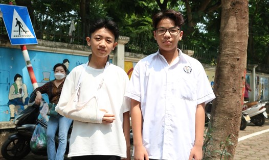 Học sinh gãy tay được "đàn em" hỗ trợ trong kỳ thi tuyển sinh lớp 10 tại Hà Nội. Ảnh: Trà My