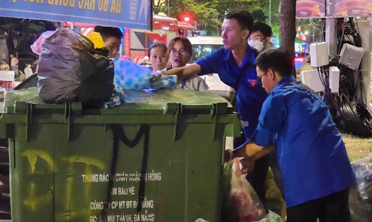 Người trẻ nhặt rác, làm sạch thành phố sau đêm pháo hoa. Ảnh: Thùy Trang