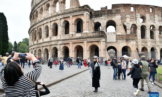 Du khách chụp ảnh trước đấu trường Colosseum ở Rome, Italy, ngày 1.5.2023. Ảnh: Xinhua