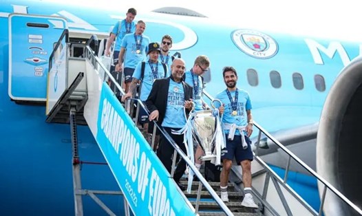 Pep Guardiola và các cầu thủ trở lại thành phố Manchester sau khi vô địch Champions League.  Ảnh: The Guardian