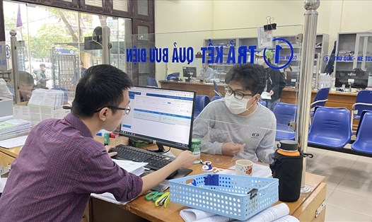 Cán bộ Bảo hiểm xã hội thành phố Hà Nội trả lời thắc mắc của người lao động về thủ tục bảo hiểm xã hội. Ảnh: Hà Anh