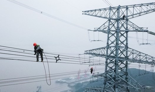 Kỹ thuật viên của Công ty Điện lực Nhà nước Chiết Giang đang kiểm tra các đường dây truyền tải điện ở Chu San, tỉnh Chiết Giang. Ảnh: Xinhua
