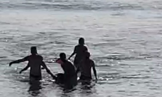 Người dân kéo người đàn ông bị đuối nước vào bờ. Ảnh: B.Phòng.
