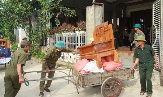 Lực lượng các đoàn thể giúp hộ dân ở xã Trung Lộc di dời tài sản đến nơi ở mới. Ảnh: Minh Đông.