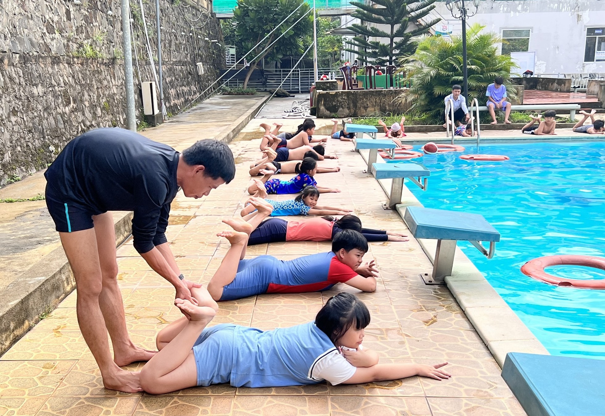 Thầy giáo hướng dẫn các em nhỏ kiến thức kỹ năng bơi lội. Ảnh: Lê Cung