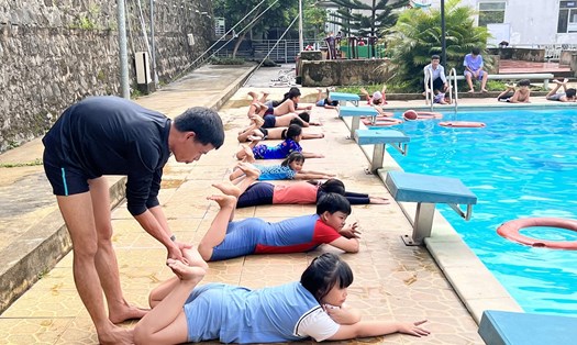 Thầy giáo hướng dẫn các em nhỏ kiến thức kỹ năng bơi lội. Ảnh: Lê Cung