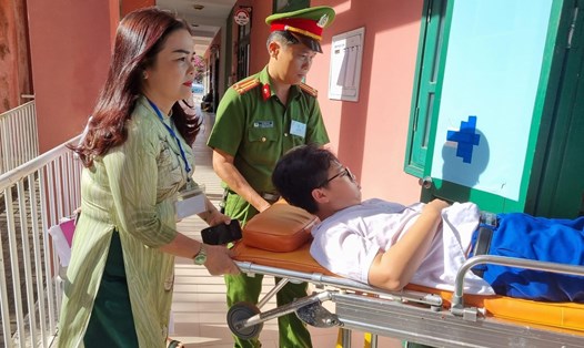 Bà Lê Thị Hương đưa thí sinh gãy chân vào phòng thi. Ảnh: Tú Linh
