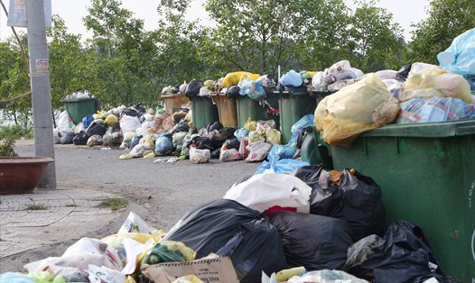 Công ty dừng việc thu gom rác thải vì chưa nộp đủ tiền phí khiến rác thải ứ đọng hơn 10 ngày qua tại đường vào chợ Xuân Hiệp, huyện Trà Ôn. Ảnh: Hoàng Lộc