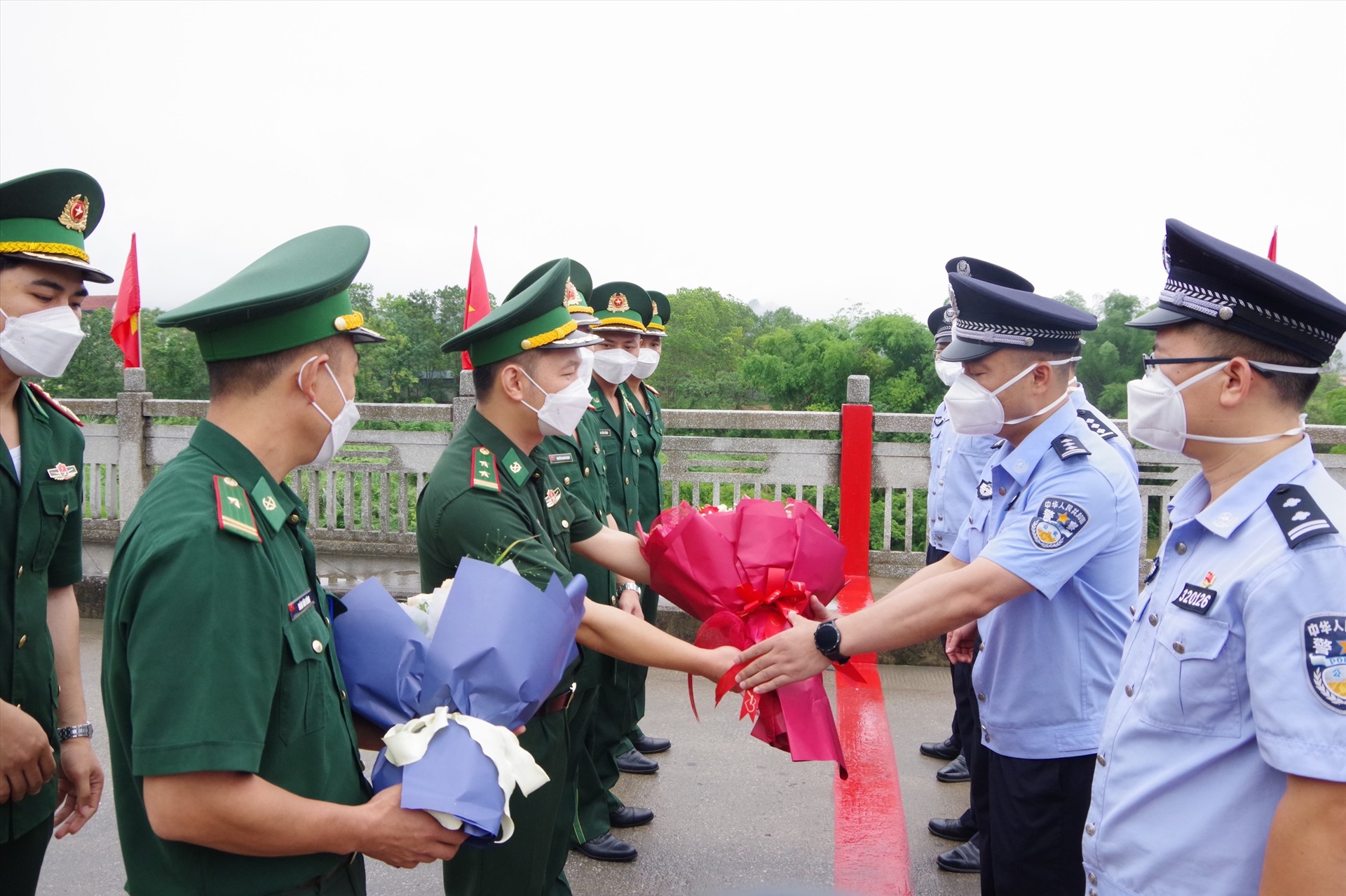 Lực lượng chức năng 2 nước tặng hoa chúc mừng khôi phục cửa khẩu. Ảnh: H.D