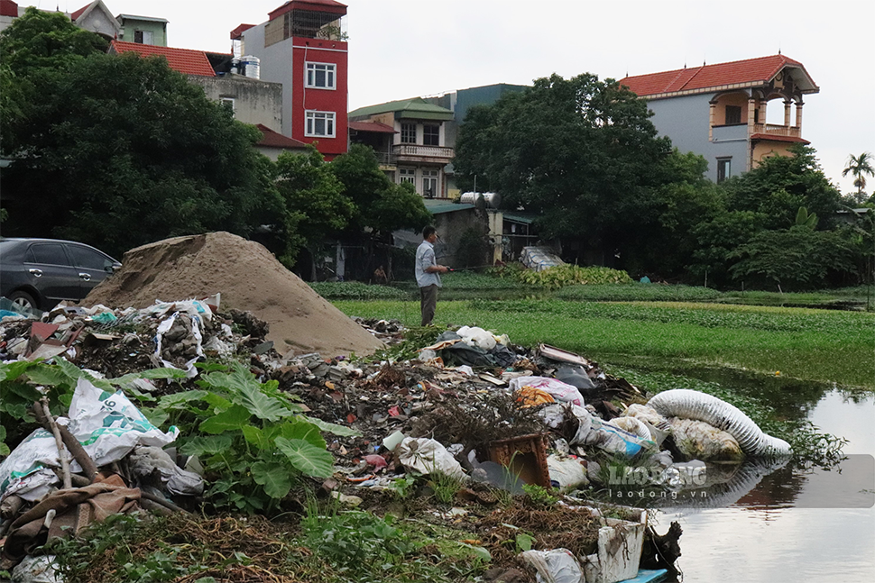Tại ngõ 99 Định Công (quận Hoàng Mai) đối diện sân bóng một ao có diện tích khá lớn đang trong tình trạng bị san lấp đổ rác và kinh doanh vật liệu xây dựng.