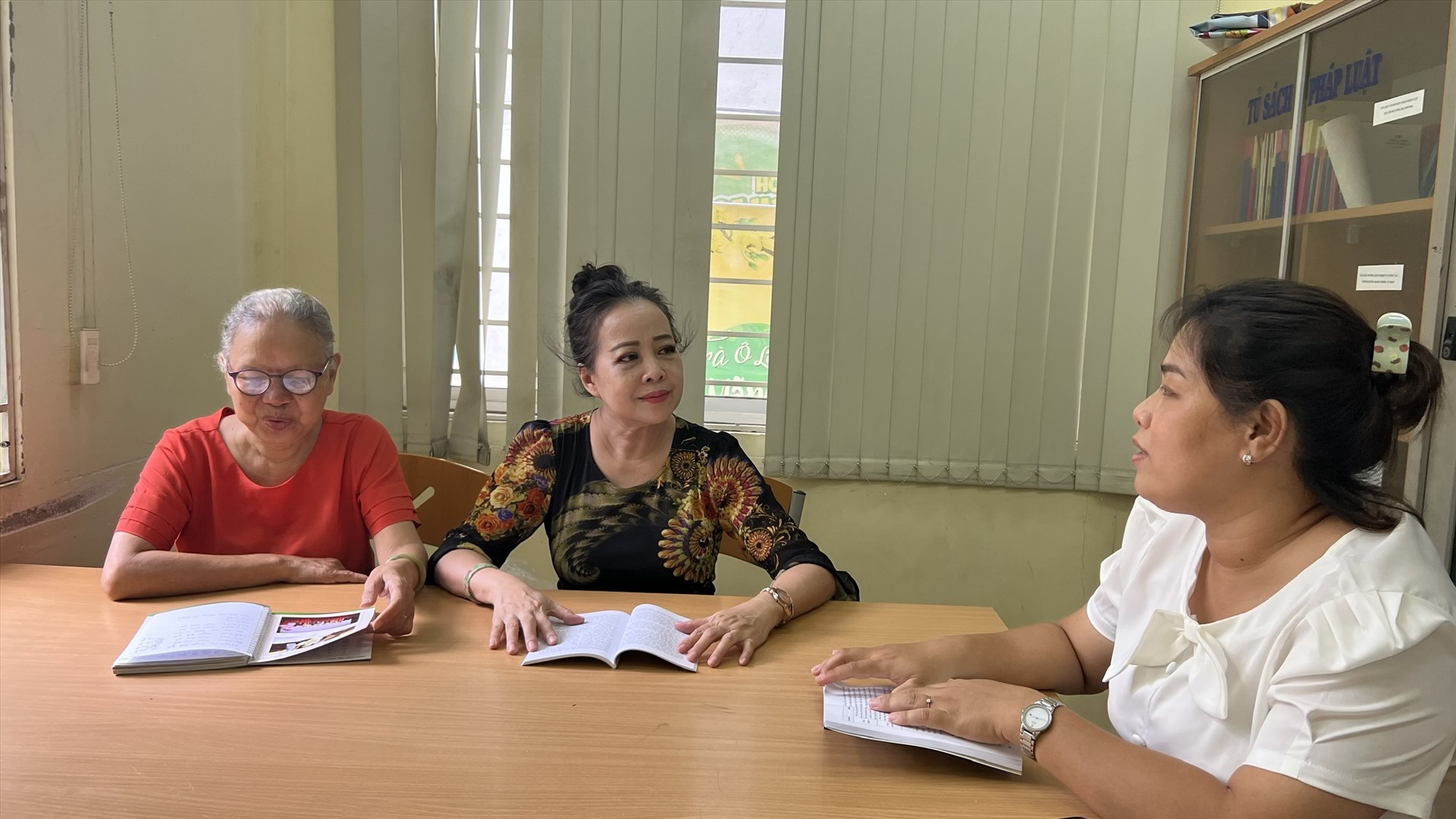 Bà Phương Thanh (ở giữa) đang cùng đồng nghiệp trao đổi công việc. Ảnh: NGUYỄN LY