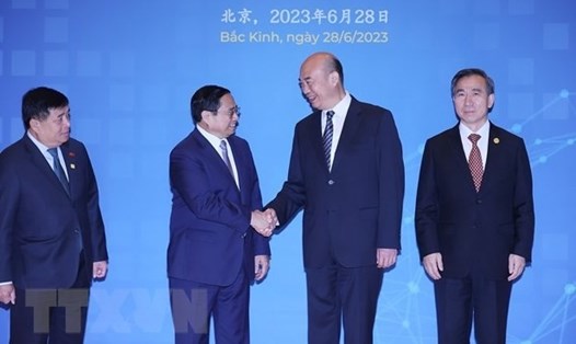 Thủ tướng Chính phủ Phạm Minh Chính bắt tay Phó Thủ tướng Trung Quốc Lưu Quốc Trung tại diễn đàn. Ảnh: TTXVN