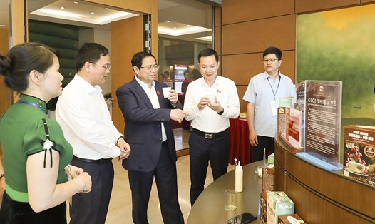 Thủ tướng Chính phủ Phạm Minh Chính và các đại biểu Quốc hội thưởng thức cà phê Arabica Mường Ảng và tham quan góc trưng bày sản phẩm bên hành lang Quốc hội. Ảnh: PV
