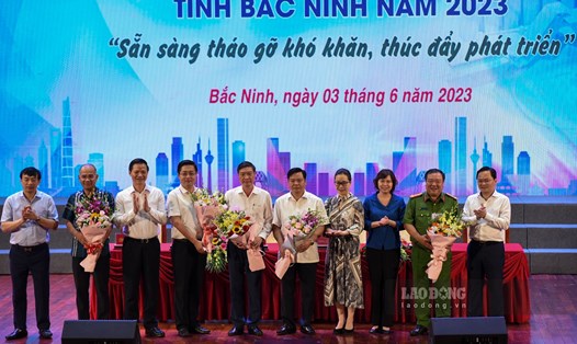 Lãnh đạo tỉnh Bắc Ninh và VCCI tặng hoa chúc mừng 5 tổ chuyên gia gỡ khó. Ảnh: Trần Tuấn