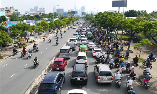 Xe cộ xếp hàng dài trên đường Nguyễn Hữu Thọ chờ qua cầu Kênh Tẻ để vào trung tâm TPHCM.  Ảnh: Minh Quân