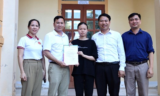 Đại diện Trường Đại học Kinh tế Nghệ An trao giấy báo trúng tuyển cho em Hoàng Thị Hải Yến. Ảnh: Hải Đăng