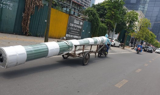 Chiếc xe này kéo theo hàng hóa rất cồng kềnh di chuyển trên phố Hoàng Quán Chi (Cầu Giấy, Hà Nội). Ảnh: Phạm Đông