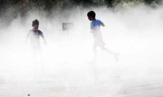 Trẻ em giải nhiệt trong bể phun sương ở công viên Queens ở thành phố New York, Mỹ trong nắng nóng. Ảnh: AFP