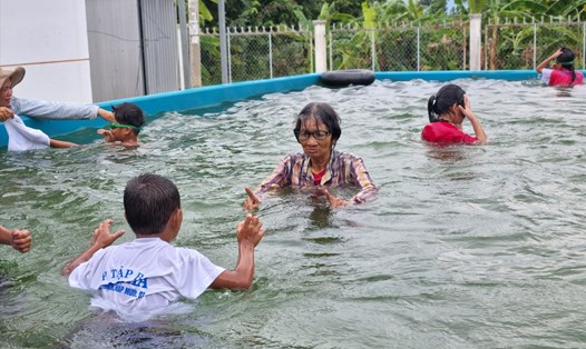 Bà Sáu dạy bơi miễn phí cho trẻ nhỏ. Ảnh: Hoàng Lộc