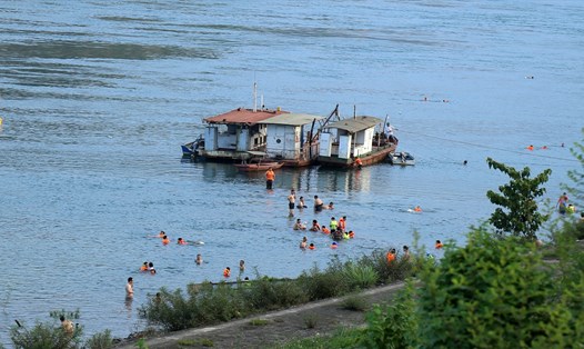 Người dân vẫn tắm sông Đà giải nhiệt, bất chấp cảnh báo nguy hiểm. Ảnh: M.N