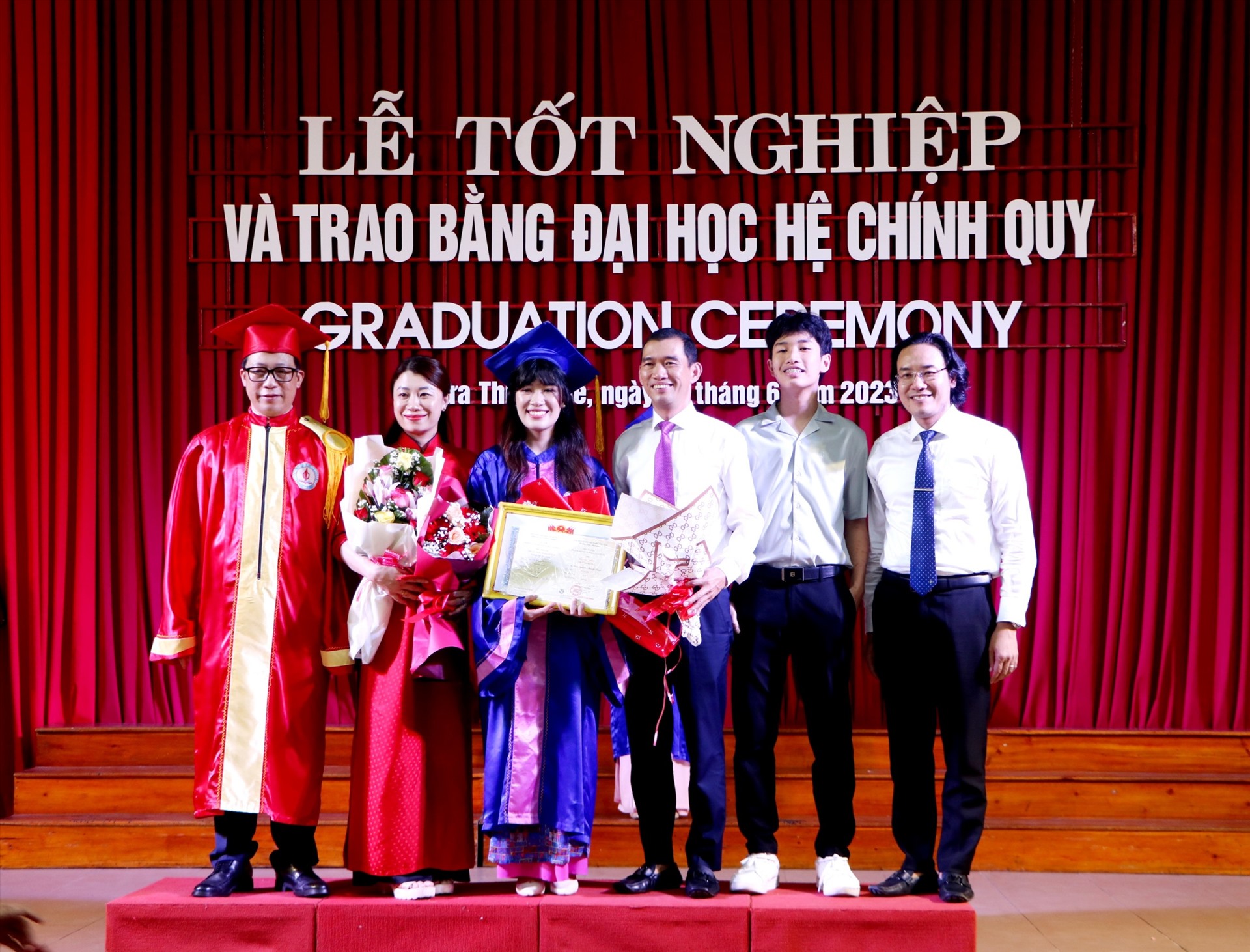 PGS. TS Lê Anh Phương (ngoài cùng, bên trái) - Giám đốc Đại học Huế, Hiệu trưởng Trường Đại học Sư phạm tặng hoa chúc mừng cho tân cử nhân Đậu Nguyễn Thanh Bình - Thủ khoa Ngành Tâm lý học giáo dục khóa 2019 - 2023. Ảnh: Phúc Đạt.