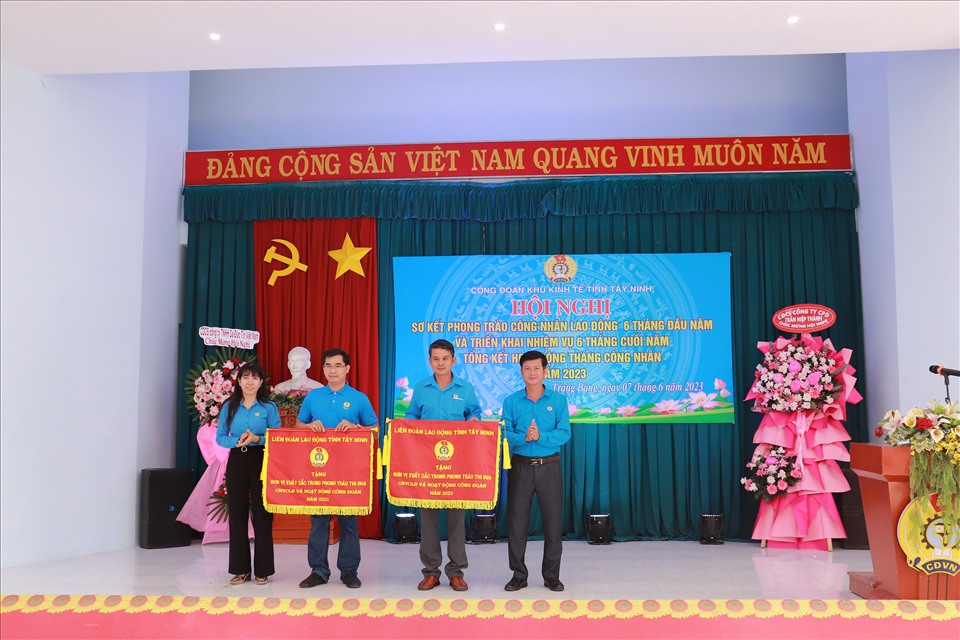 Lãnh đạo Liên đoàn Lao động tỉnh và Công đoàn Khu kinh tế trao cờ cho 2 đơn vị xuất sắc trong phong trào thi đua Công nhân lao động và hoạt động công đoàn năm 2022. Ảnh: Phương Dung
