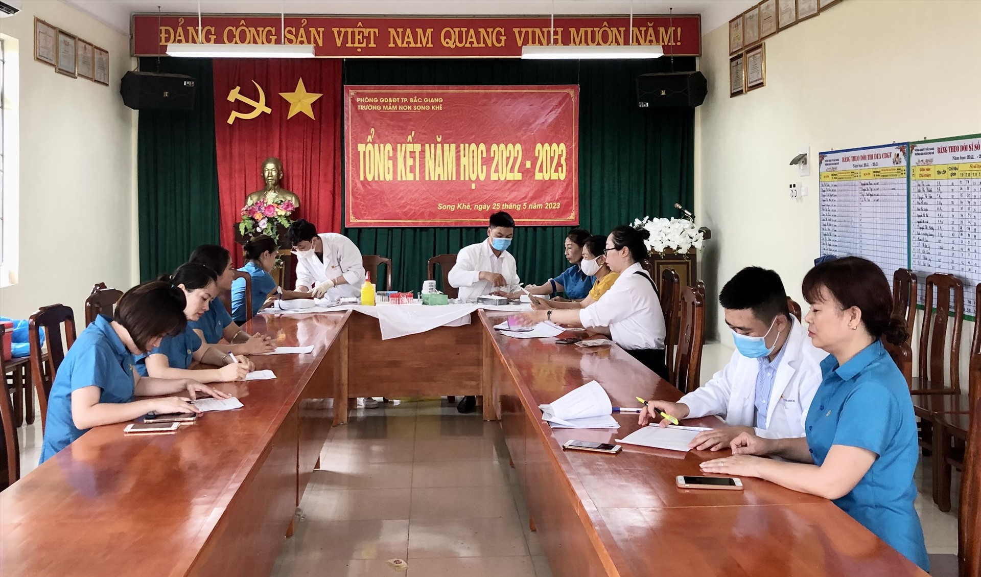 Đoàn viên Trường Mầm non Song Khê được các nhân viên y tế hướng dẫn đăng ký khám và lấy máu xét nghiệm. Ảnh: Bùi Văn Khước 