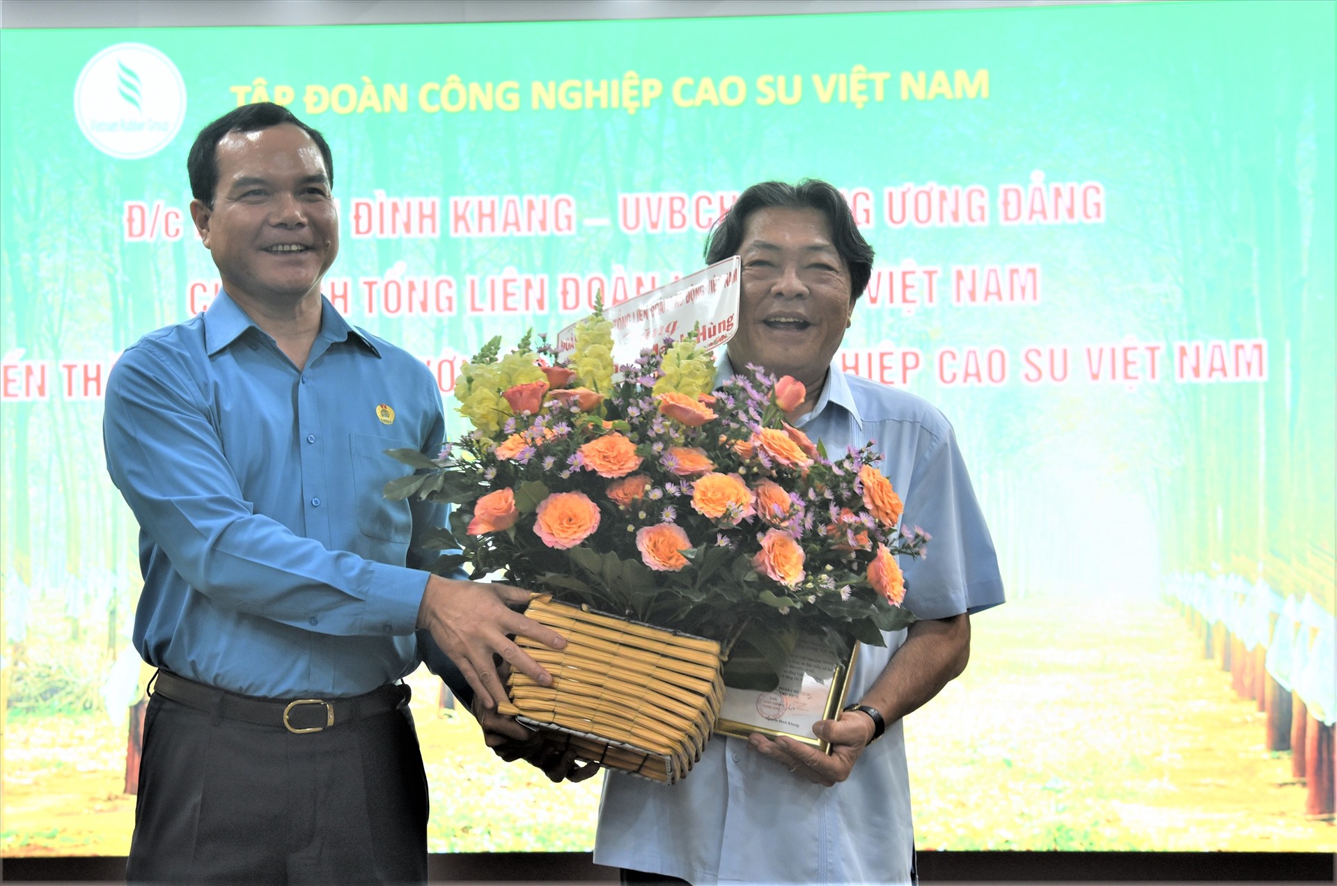Chủ tịch Tổng LĐLĐ Việt Nam Nguyễn Đình Khang (trái) trao quyết định, tặng hoa ông Phan Mạnh Hùng. Ảnh: Nam Dương
