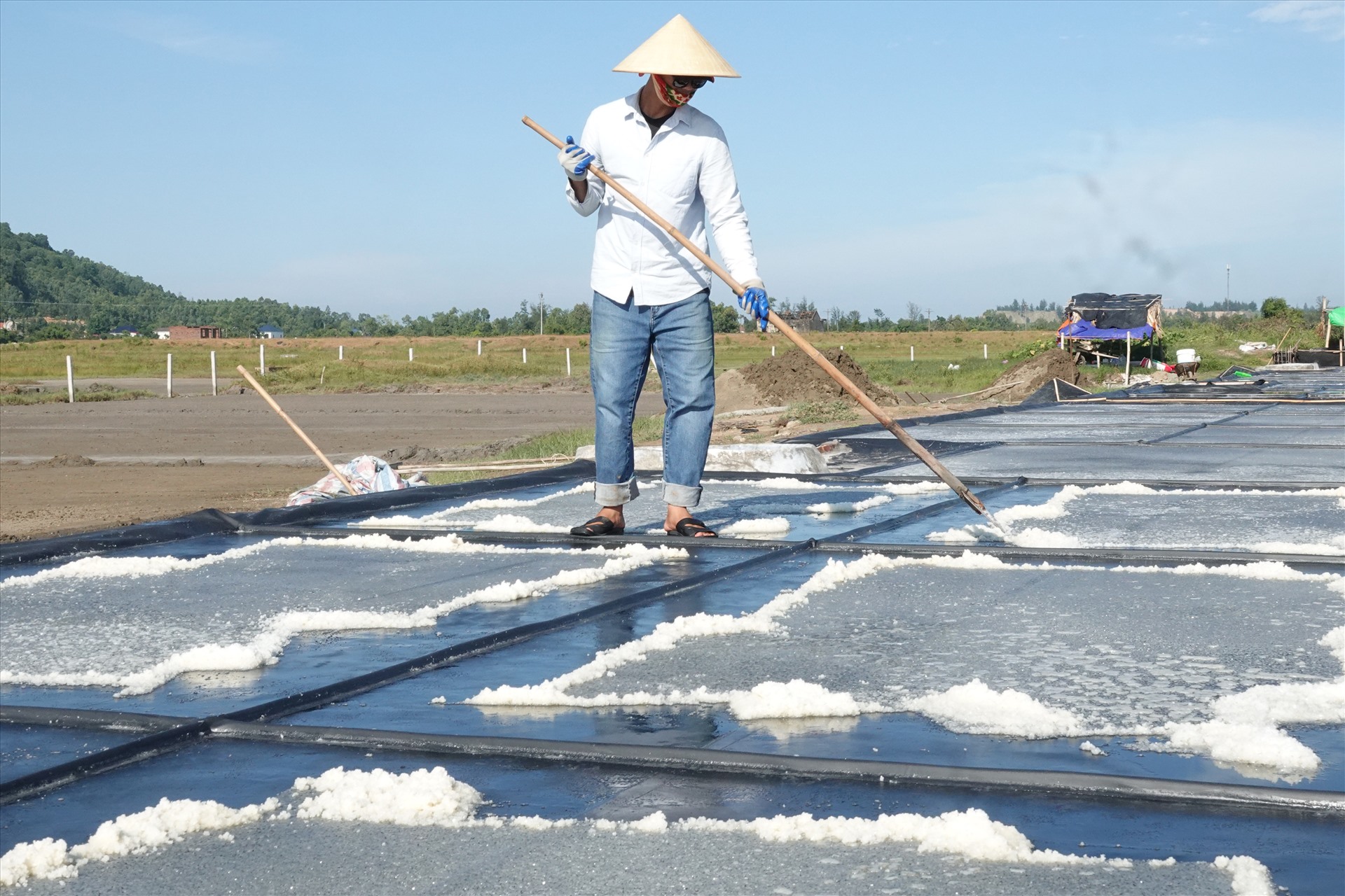 Thu gom muối trên mô hình sản xuất muối sạch trên ô kết tinh trải bạt ở xã Đỉnh Bàn. Ảnh: Trần Tuấn.