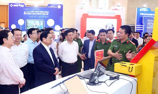 Thủ tướng Phạm Minh Chính và các đại biểu tham quan gian trưng bày các mô hình chuyển đổi số. Ảnh: TTXVN