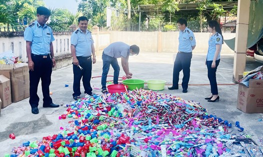 Lực lượng QLTT tỉnh Quảng Bình tổ chức tiêu hủy các sản phẩm là hàng hóa nhập lậu và hàng hóa giả mạo nhãn hiệu. Ảnh: Cục QLTT Quảng Bình