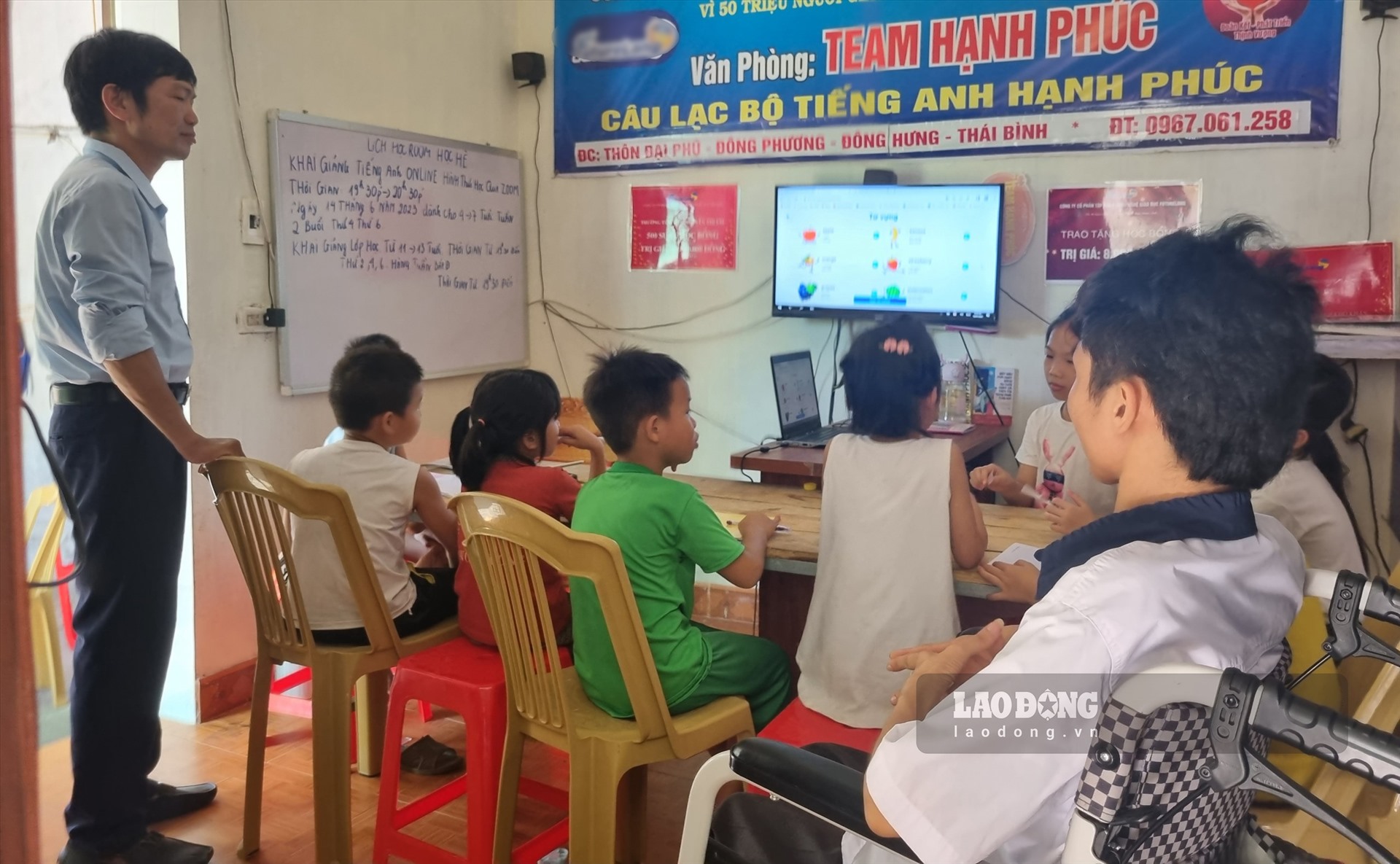 Anh Điển và thầy Cương phối hợp dạy Tiếng Anh cho các bạn nhỏ. Ảnh: Lương Hà
