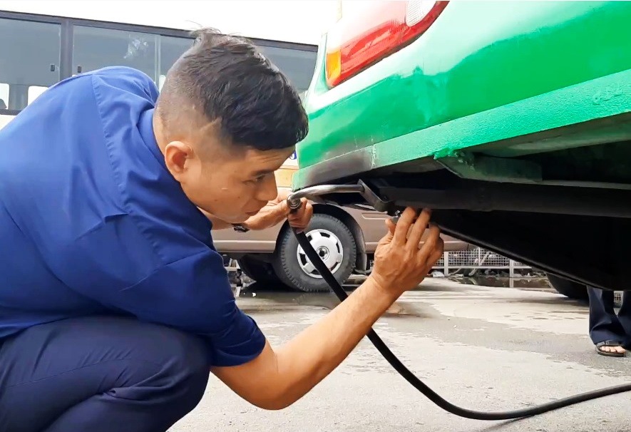 Lực lượng chức năng gắn thiết bị đo khí thải đối với xe buýt tại bến xe Miền Tây (quận Bình Tân, TPHCM). Ảnh: Minh Quân