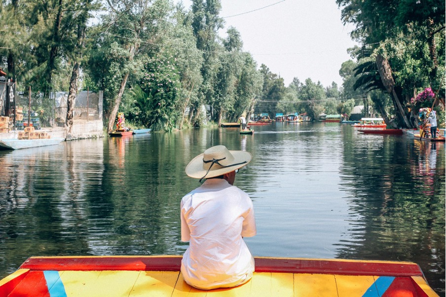 Du khách trên chiếc thuyền gỗ trajineras ngắm nhìn dòng kênh xanh.