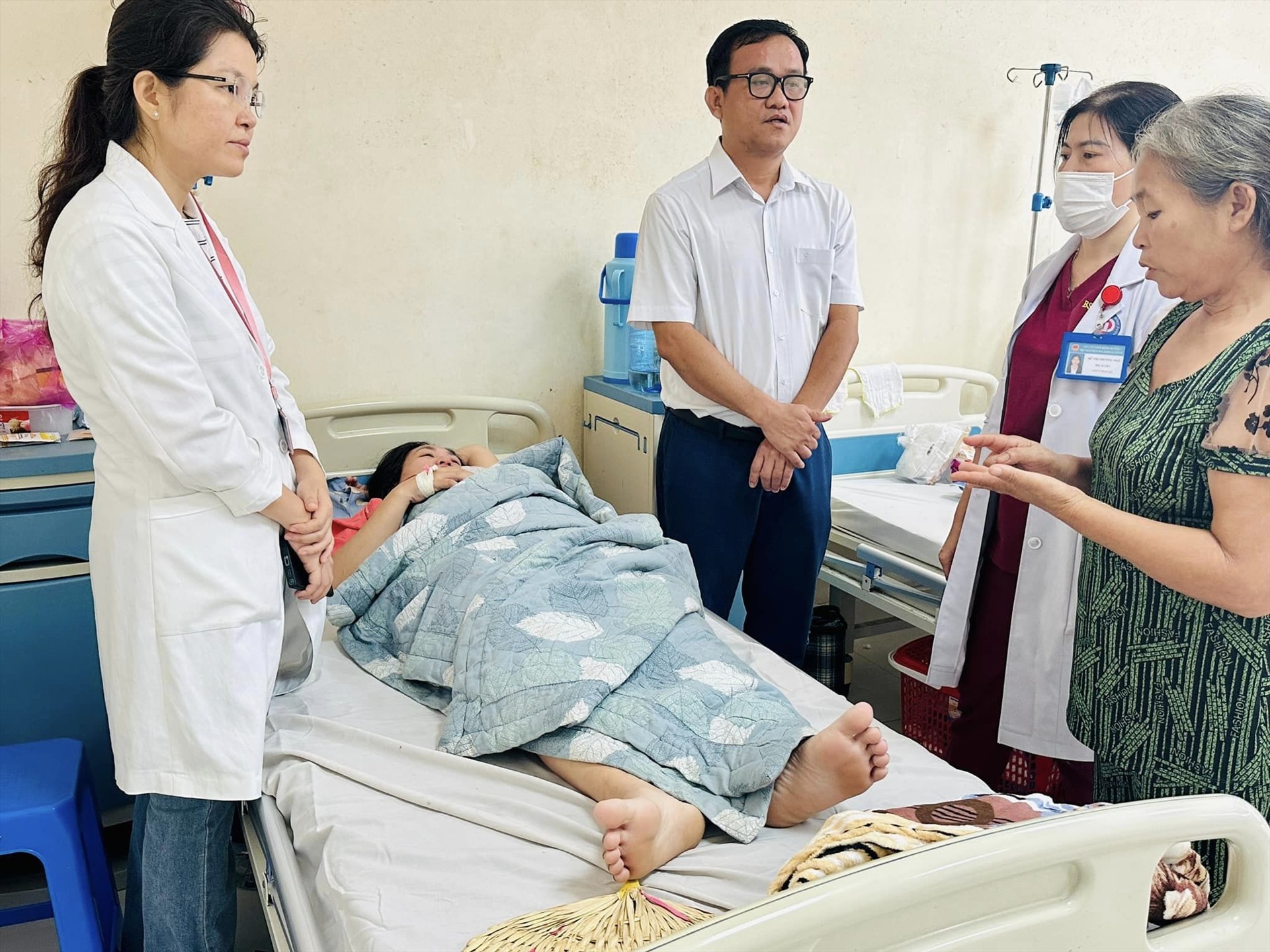 Bác sĩ Huỳnh Minh Chín cùng bác sĩ bệnh viện thăm khám cho bệnh nhân và trao đổi lại với người nhà. Ảnh: NVCC