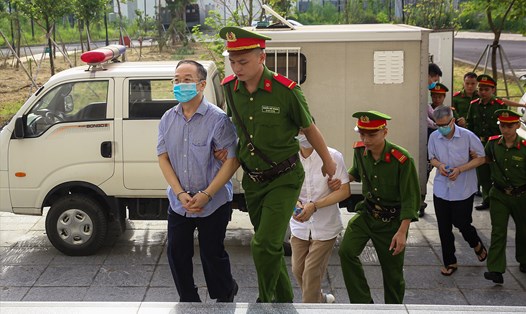 Cảnh sát dẫn giải các bị cáo trong vụ chuyến bay giải cứu vào phòng xử. Ảnh: Quang Việt