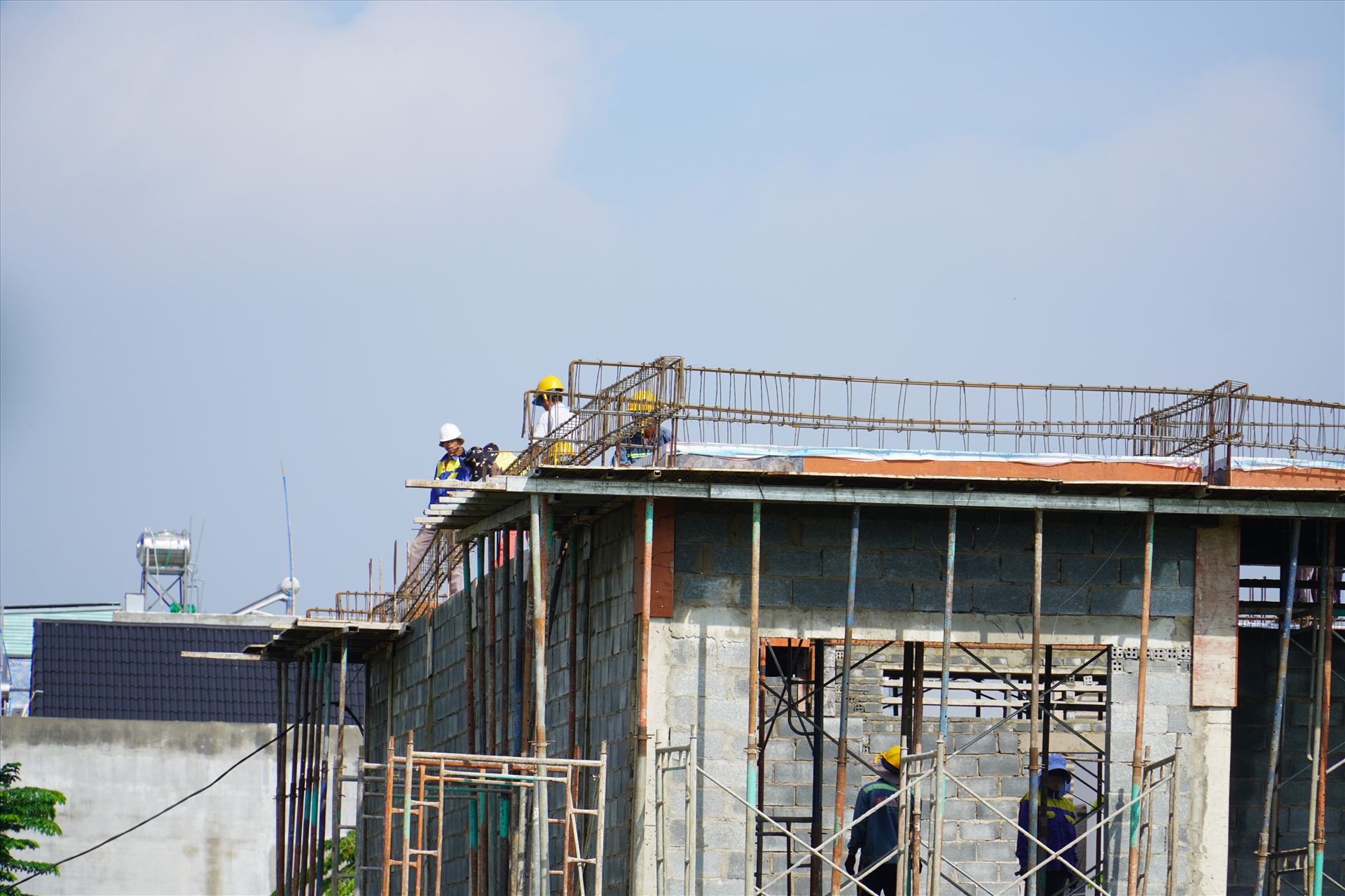 Người lao động thi công các công trình xã hội trong khu tái định cư Lộc An - Bình Sơn. Ảnh: Hà Anh Chiến
