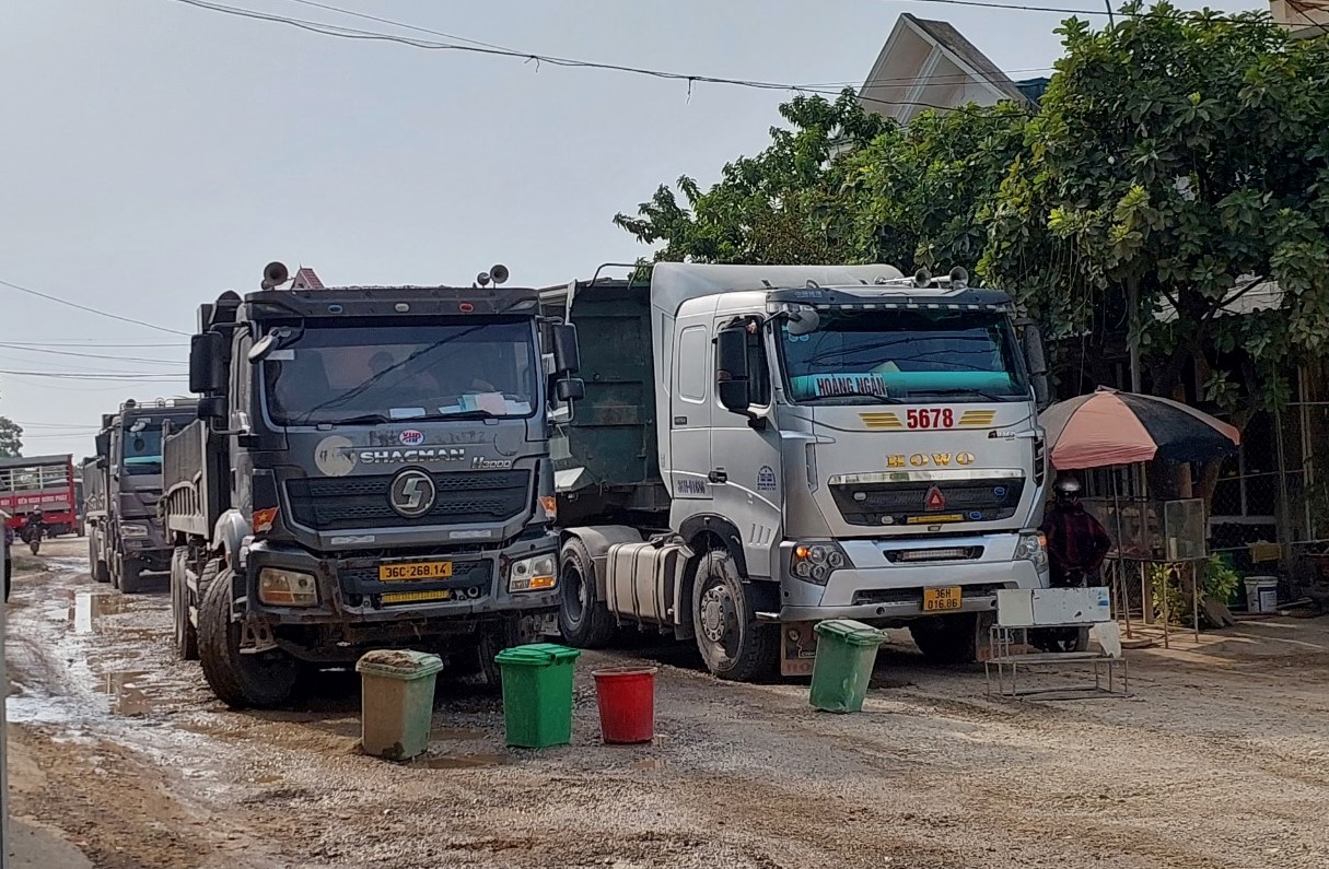 Người dân mang thùng rác, vật dụng ra chặn đường xe tải chở đất vào sáng ngày 16.7. Ảnh: Minh Hoàng
