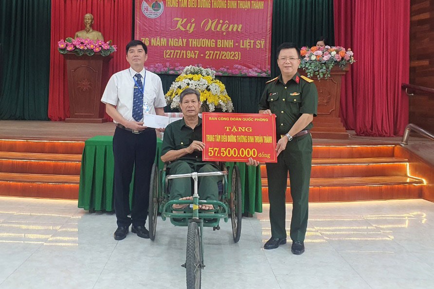 Đại tá Nguyễn Đình Đức trao tặng quà tại Trung tâm điều dưỡng thương binh Thuận Thành. Ảnh: Minh Quý
