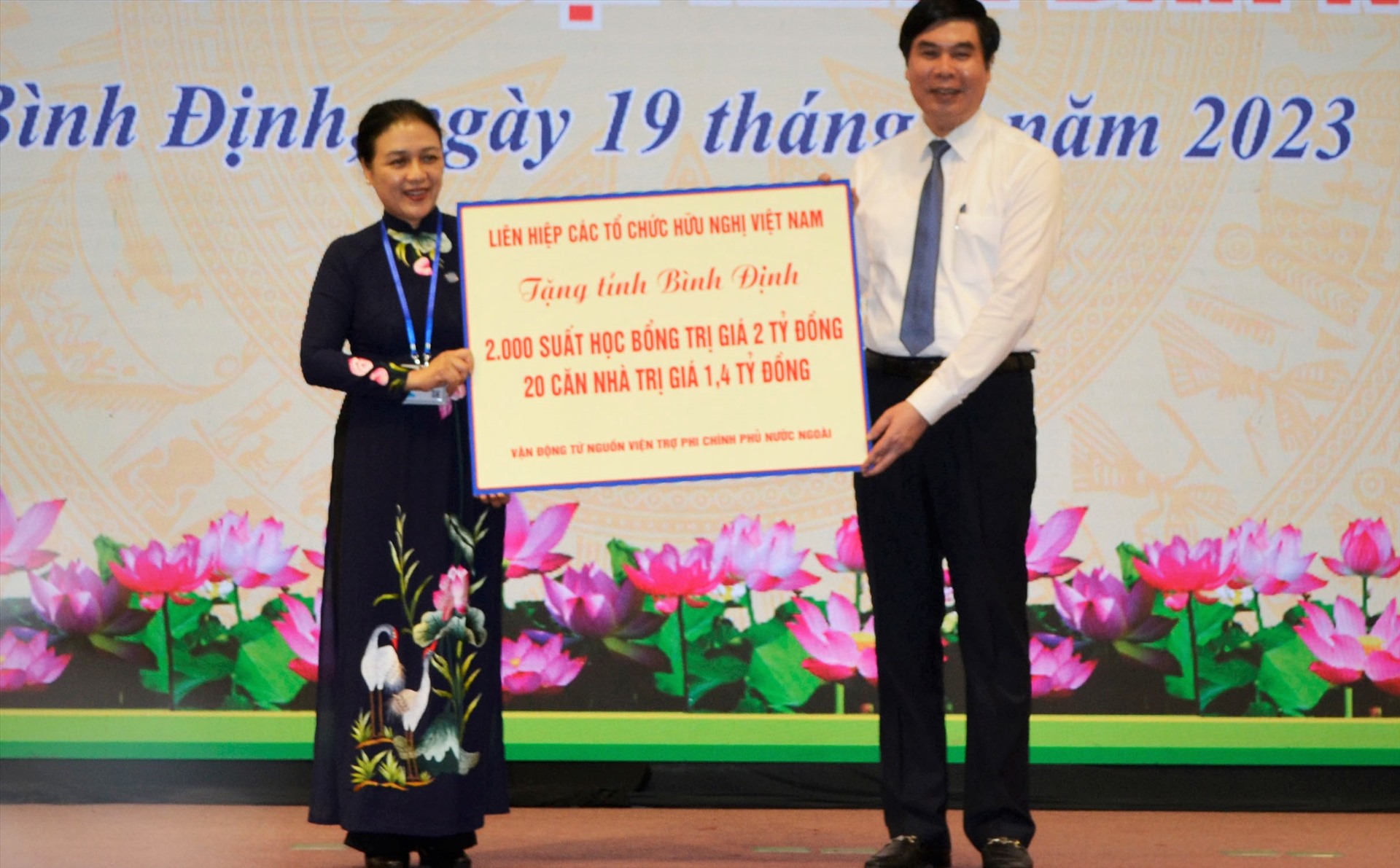 Phó Chủ tịch UBND tỉnh Bình Định Lâm Hải Giang nhận biểu trưng quà tặng cho người nghèo và học sinh khó khăn. Ảnh: Xuân Nhàn.