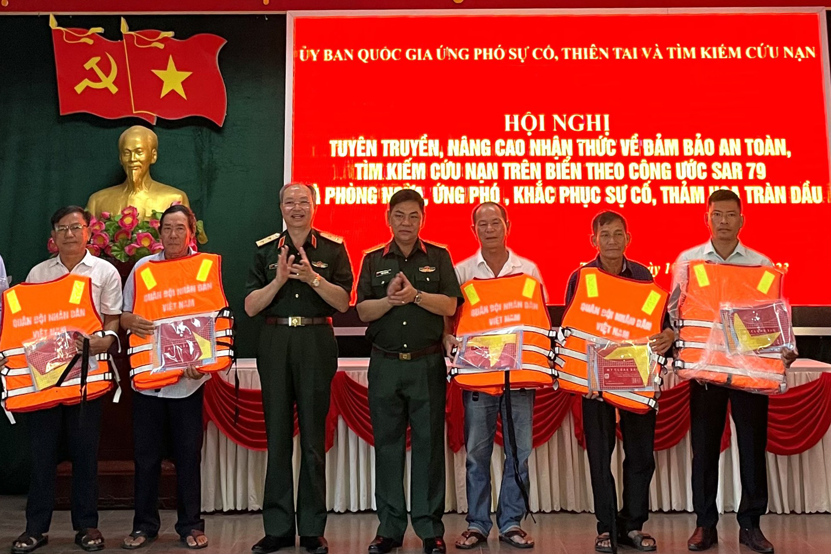 Trung tướng Doãn Thái Đức tặng áo phao và cờ Tổ quốc cho các ngư dân phường Thuận An. Ảnh: Võ Tiến.