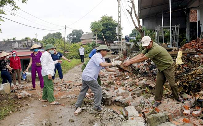 Người dân thị trấn Mậu A, huyện Văn Yên tình nguyện dỡ bỏ tường rào kiên cố, hiến đất để mở rộng tuyến đường giao thông nông thôn. Ảnh: Thu Trang