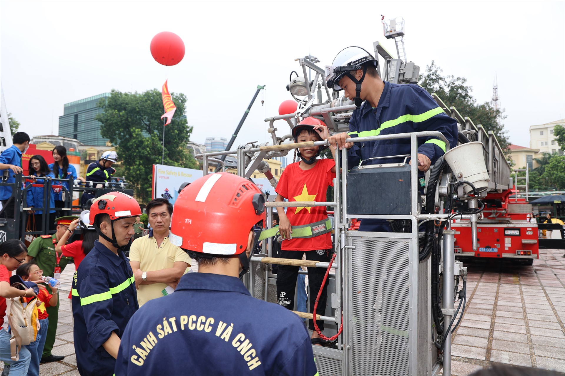 Khách tới tham quan triển lãm được trải nghiệm các hoạt động liên quan tới thoát nạn bằng xe thang. Ảnh: Ái Vân