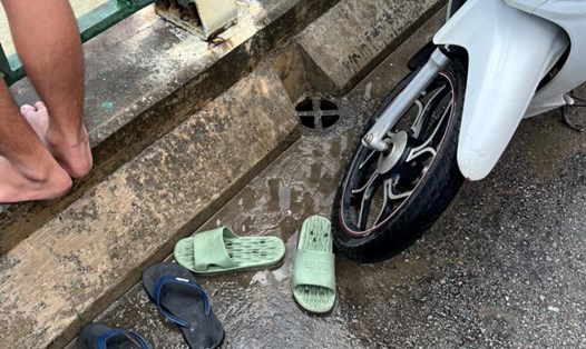 Chiếc xe máy cùng đôi dép nam thanh niên để lại trên cầu Bến Thủy 2. Ảnh: Hải Đăng