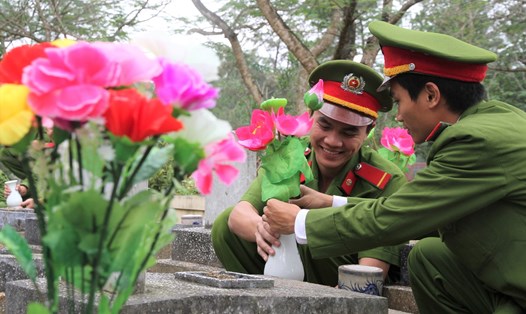 Cán bộ, chiến sĩ Công an tỉnh Quảng Trị gắn bình và hoa lên các phần mộ liệt sĩ vào năm 2017. Ảnh: Hưng Thơ.