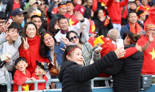 Hậu vệ Hoàng Thị Loan chụp ảnh cùng người hâm mộ Việt Nam sau trận đấu. Ảnh: Đức Đồng